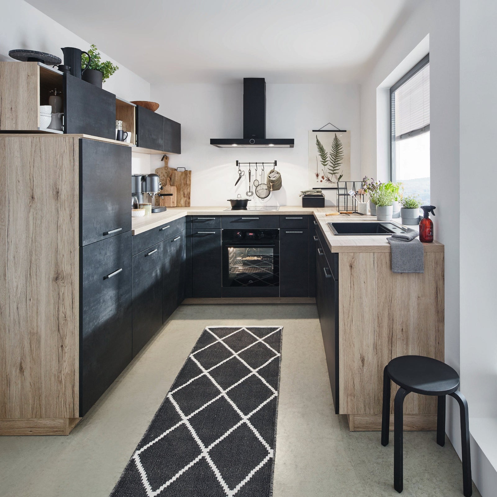 U-Küche in schwarzbeton mit Eiche und Metallgriffen