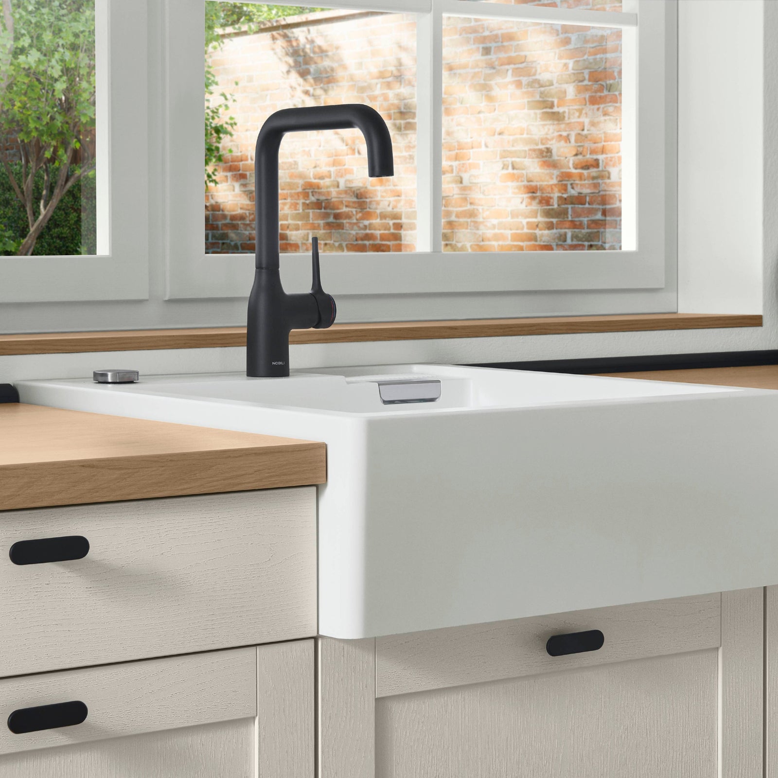 Weißes Kuechenzeilen Detail mit schwarzen Griffen und schwarzer Armatur, Arbeitsplatte in Eiche