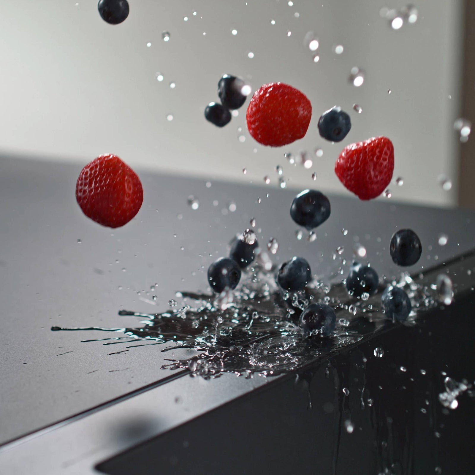 Beeren fallen auf dunkle Arbeitsplatte